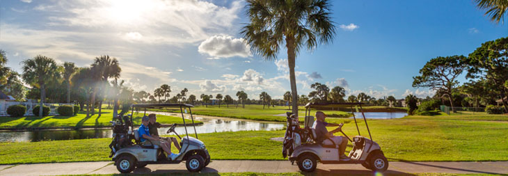People driving golf carts on a sunny day on the golf course