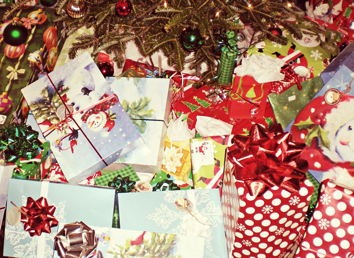 Wrapped Christmas presents with bows under a Christmas tree. Image by Melissa Etheridge from Pixabay.