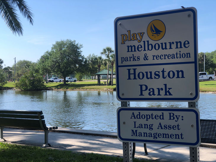 Houston Park sign with park bench overlooking the water in the background.