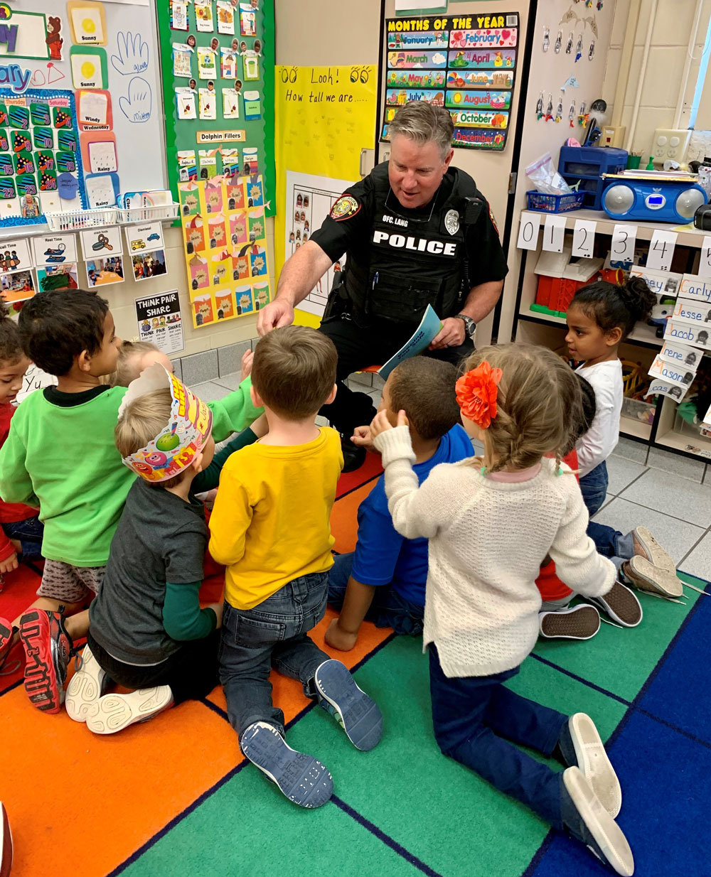 Melbourne Police Officer reading to young children in a classroom.