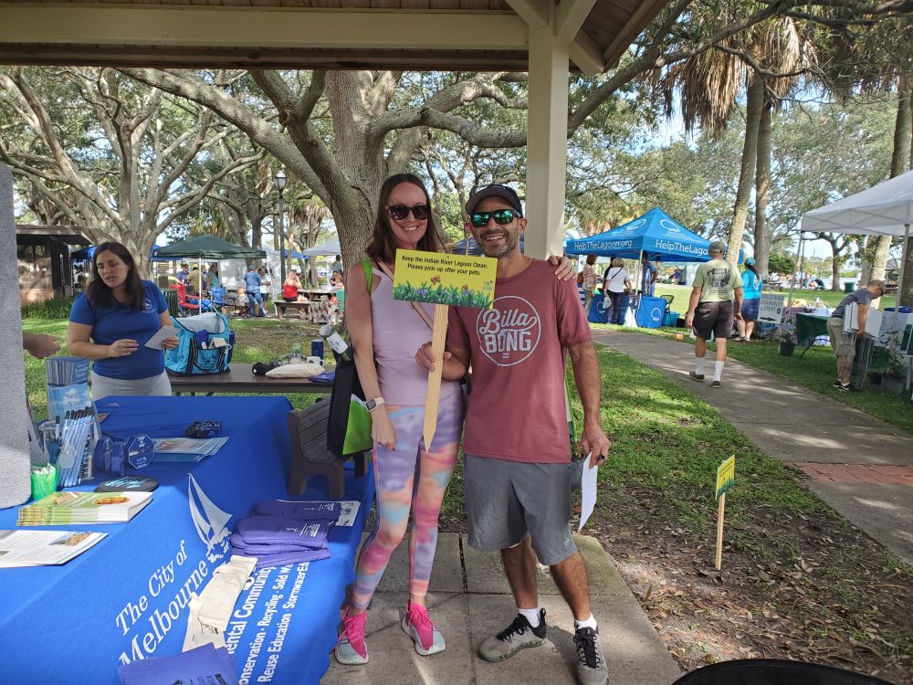 A man and a woman visit a booth at Indian River Lagoon Day at Front Street Park.