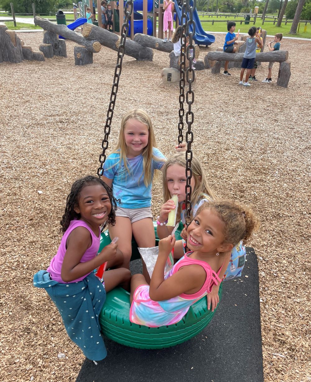 Four girls having fun on a tire swing