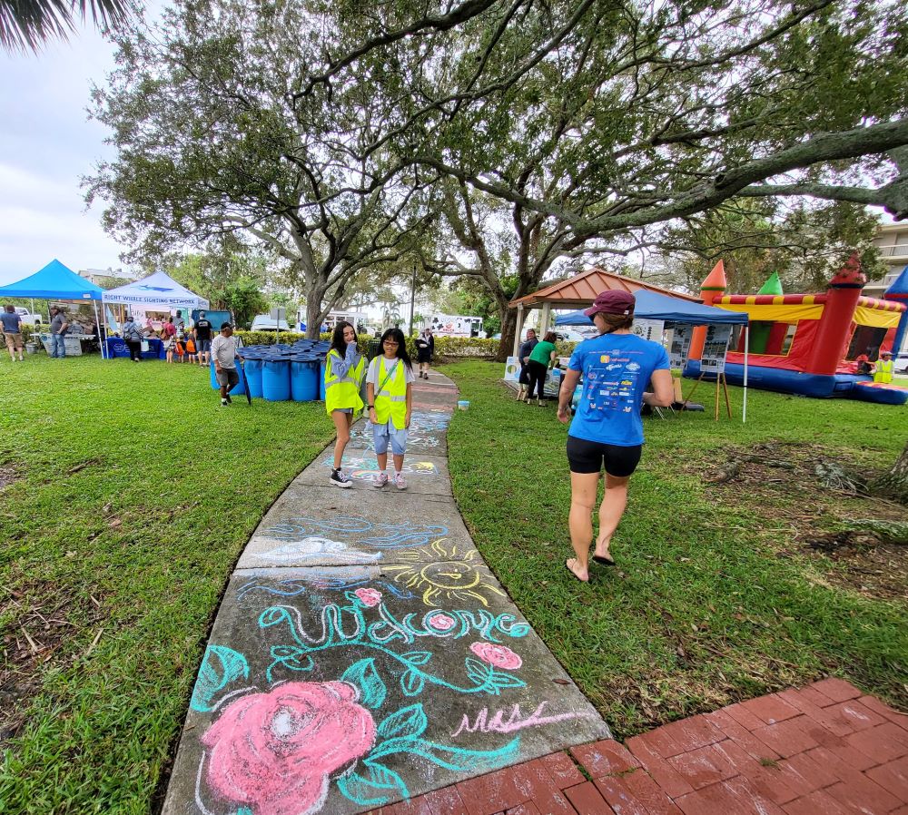 Chalk drawing on sidewalk that says "Welcome" at Indian River Lagoon Day, Front Street Park.