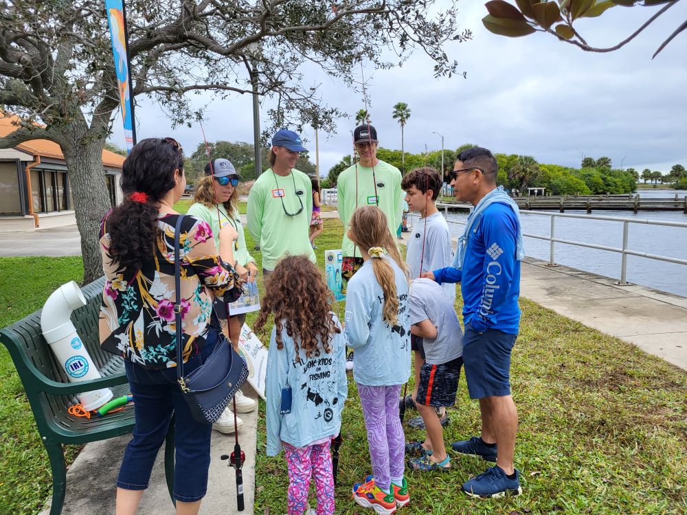 A group of kids and adults with fishing poles at Indian River Lagoon Day, Front Street Park.