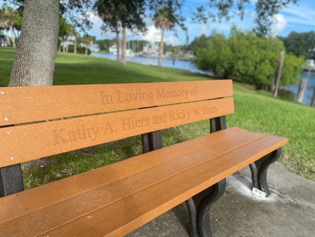 Memorial wooden bench at Ballard Park with the river in the background