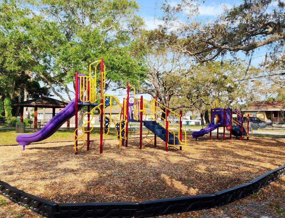 colorful playground equipment in a shady park