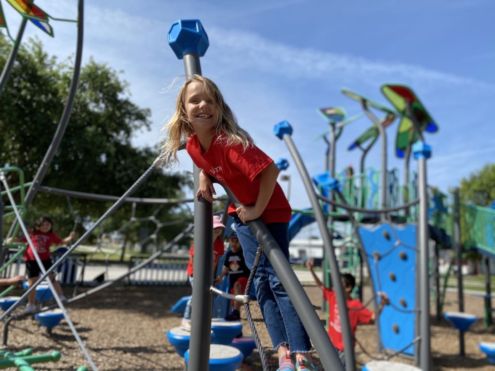 girl climbing on playground equipment