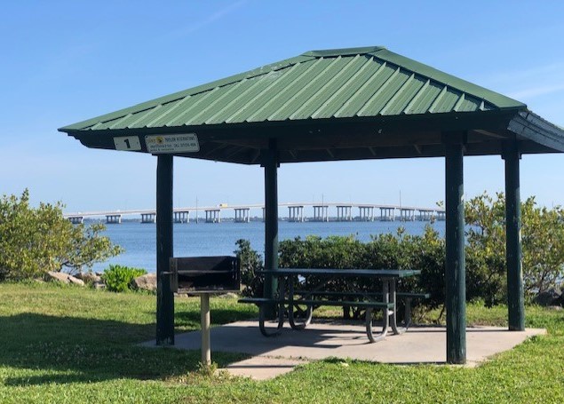 Pavilion with picnic table and grill with a view of the Indian River Lagoon and the Melbourne Causeway