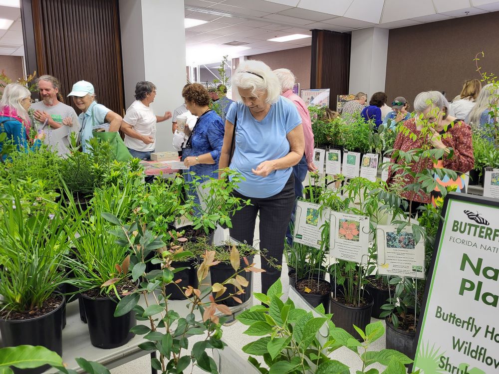 Florida Friendly Landscaping Seminar attendees look at native plants on display inside the auditorium